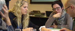 Four teachers sitting around a desk looking at papers