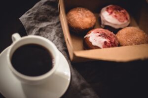 Cup of coffee and a box of four donuts